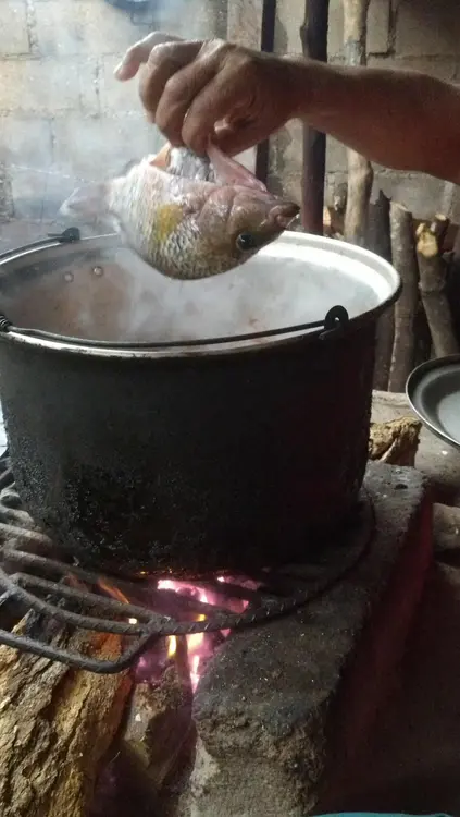 Preparando un rico caldo de mojarra de rio recien pescado.